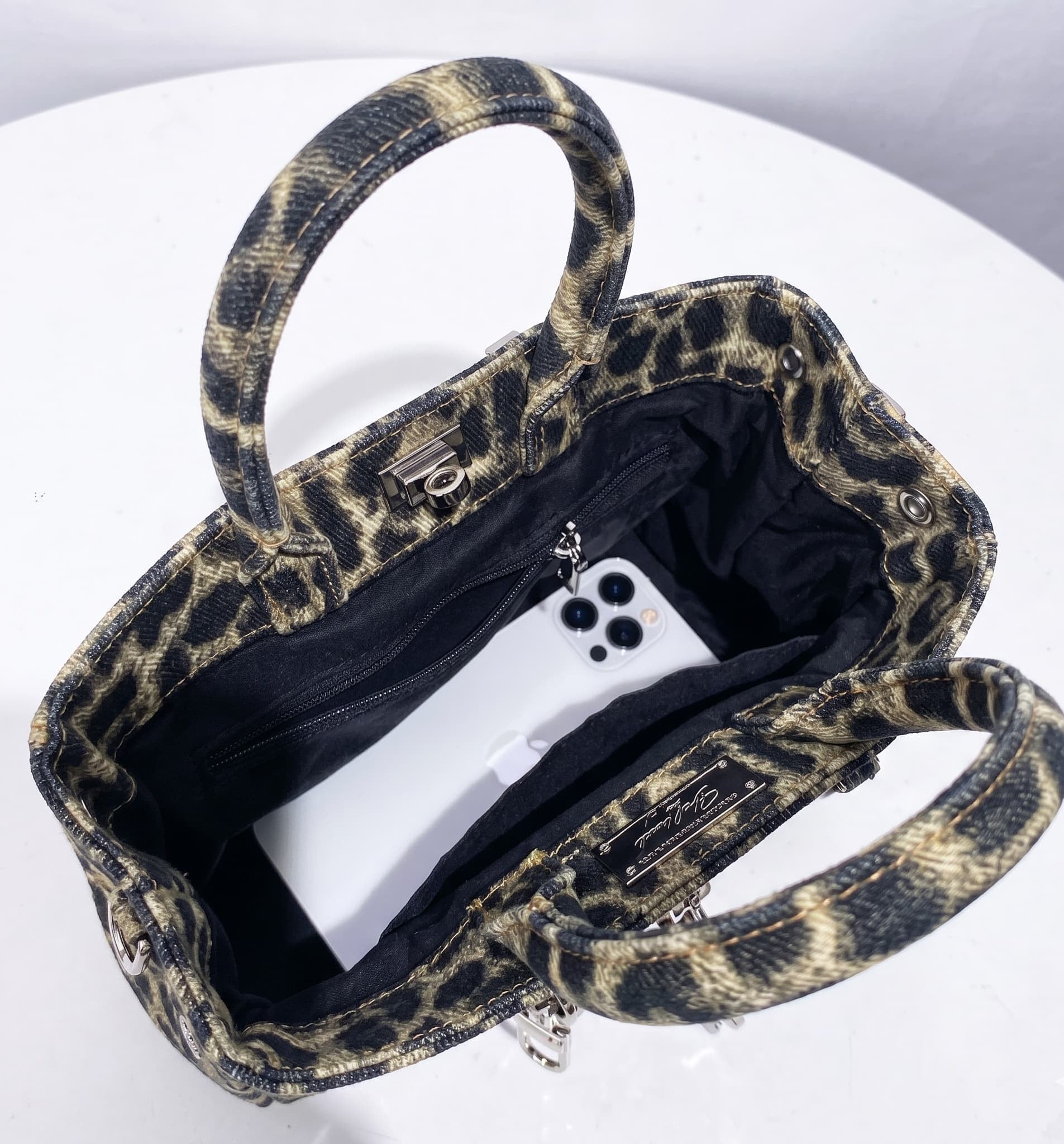 Leopard print handbag with a phone inside on a white background