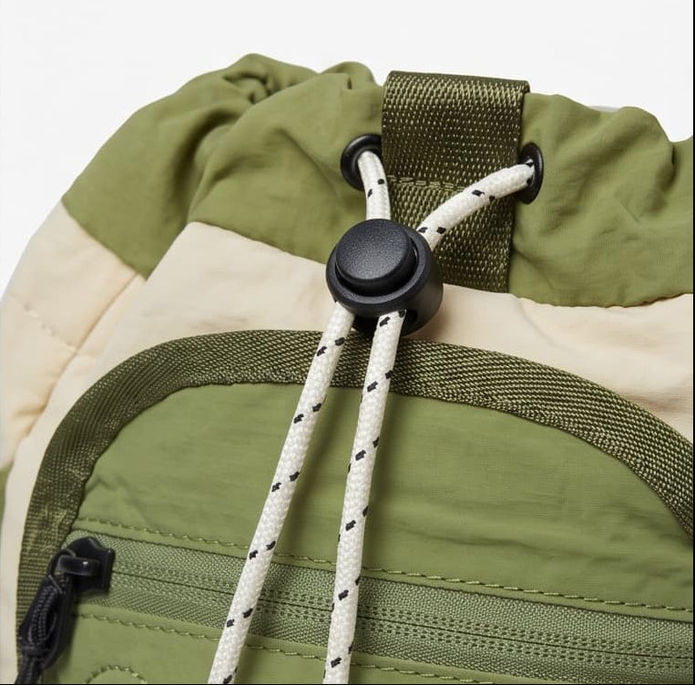 A 6-panel product collage showing an adventurer drawstring backpack from multiple angles on a white background. The panels include an overview, main compartment with lining, side access pocket and magnetic flap close, front zippered pocket detail, and drawstring toggle detail.