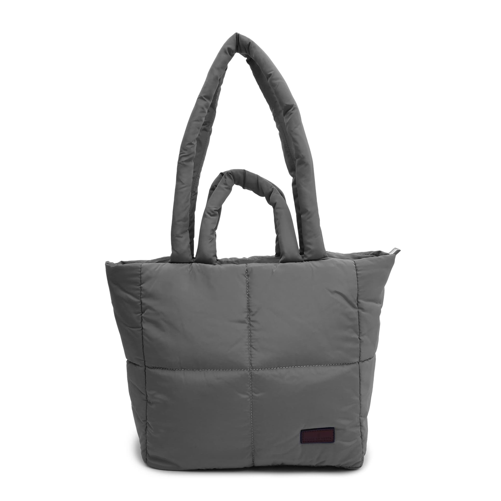 Gray quilted tote bag with a small label on a white background "Minimalist shoulder bag with a structured silhouette, single top strap, and attached tag detail – designed for effortless everyday style. Compact yet spacious enough for daily essentials, perfect for work, brunch, or casual wear. A premium fashion accessory from Tales of Totes, ideal for Indian shoppers seeking elegant, functional handbags beyond standard tote designs."
