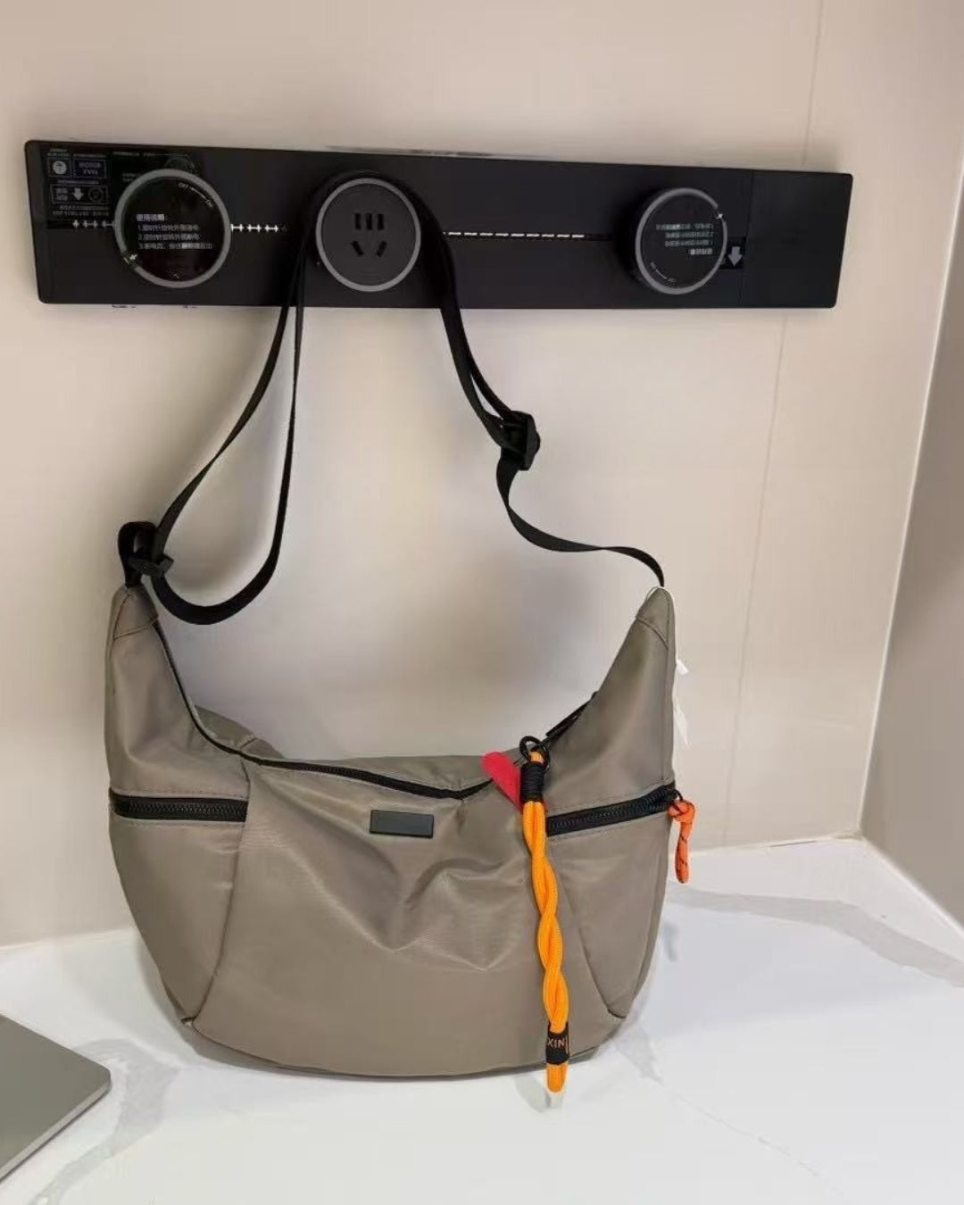 Black bag with orange interior on a light gray background.Waterproof tote bag with a durable exterior and a bright orange interior. Features an adjustable strap and multiple pockets for organization. Ideal for travel, gym, or daily use in India.