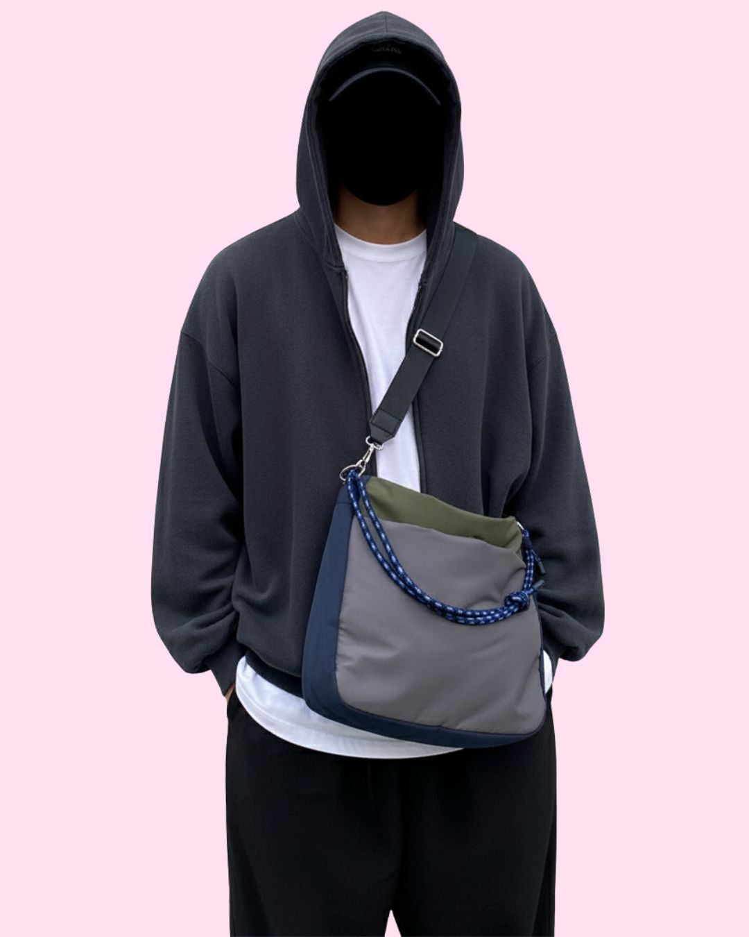 Person wearing a dark hoodie with a crossbody bag on a pink background,Woman standing outside a house holding a colorful bag Multi-pocket travel tote bag with 20-litre capacity and compact dimensions (35 x 35 x 10 cm), featuring a wide adjustable strap and color-blocked utility design. Lightweight, durable, and ideal for travel, college, or daily use. A high-performance everyday essential from Tales of Totes – built for comfort, style, and smart organization in India’s fast-paced lifestyle."
