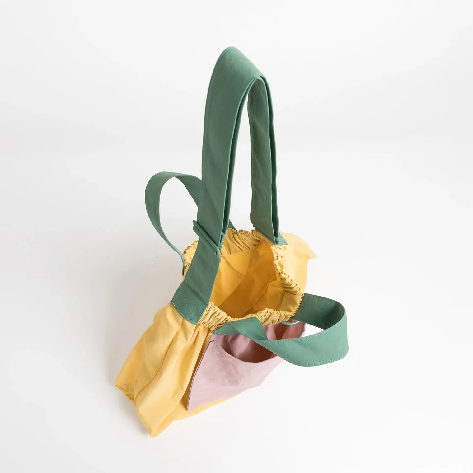 Colorful fabric bag with green handle on a white background