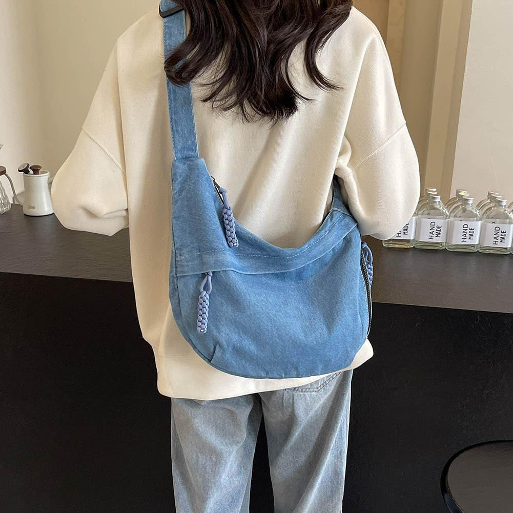 Sleek mini tote bag in deep-wash denim, featuring front and side zip pockets and braided pull detail