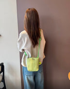 Small in size, strong in character.

This compact sling bag is built around a tall, bucket-style silhouette with a tactile textured outer body and a soft drawstring inner pouch. The long rope strap keeps the look relaxed and functional, while knotted details and utility hardware give it a more experimental feel than a conventional mini bag.

Designed for days when you only want to carry the essentials, it sits comfortably against the body without feeling bulky. The narrow shape keeps it easy to move around 