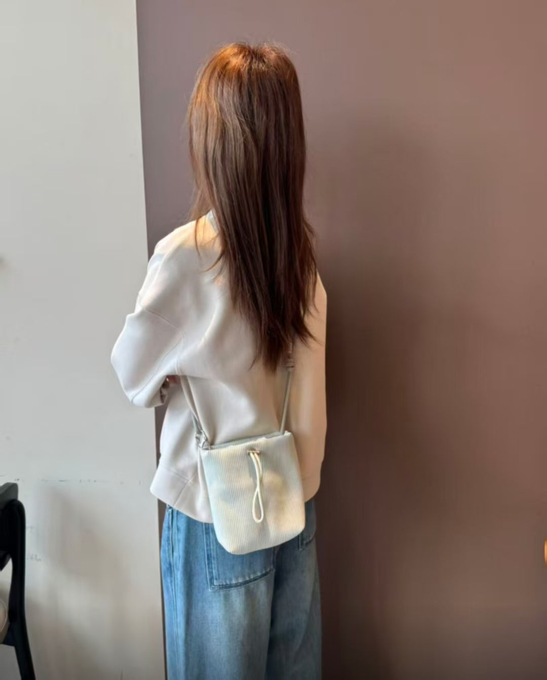 Small in size, strong in character.

This compact sling bag is built around a tall, bucket-style silhouette with a tactile textured outer body and a soft drawstring inner pouch. The long rope strap keeps the look relaxed and functional, while knotted details and utility hardware give it a more experimental feel than a conventional mini bag.

Designed for days when you only want to carry the essentials, it sits comfortably against the body without feeling bulky. The narrow shape keeps it easy to move around 