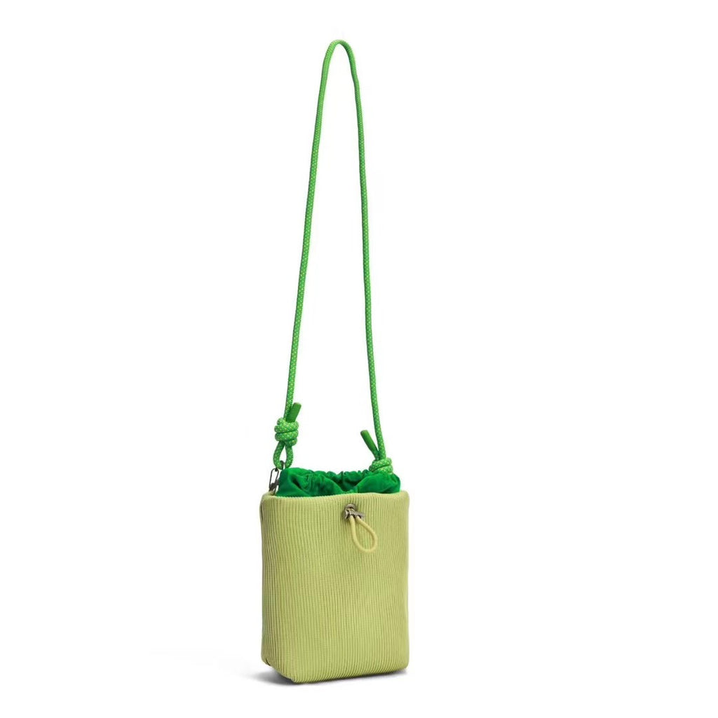 Small in size, strong in character.

This compact sling bag is built around a tall, bucket-style silhouette with a tactile textured outer body and a soft drawstring inner pouch. The long rope strap keeps the look relaxed and functional, while knotted details and utility hardware give it a more experimental feel than a conventional mini bag.

Designed for days when you only want to carry the essentials, it sits comfortably against the body without feeling bulky. The narrow shape keeps it easy to move around 
