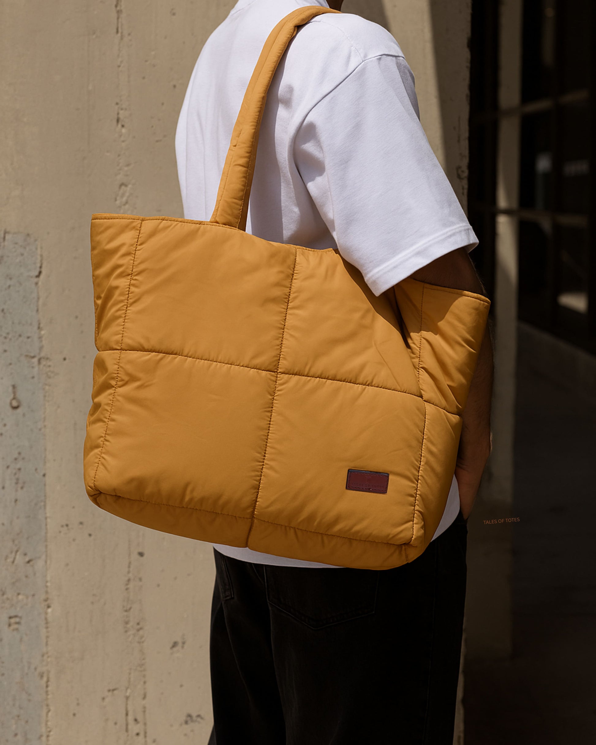 Quilted puffer tote bag with padded handles and a soft structured silhouette – lightweight, stylish, and perfect for daily use, college, travel, or shopping. Designed for comfort and statement appeal, this spacious carryall from Tales of Totes is a trendy alternative to Zouk, Lavie, and DailyObjects in India’s fashion accessories market."