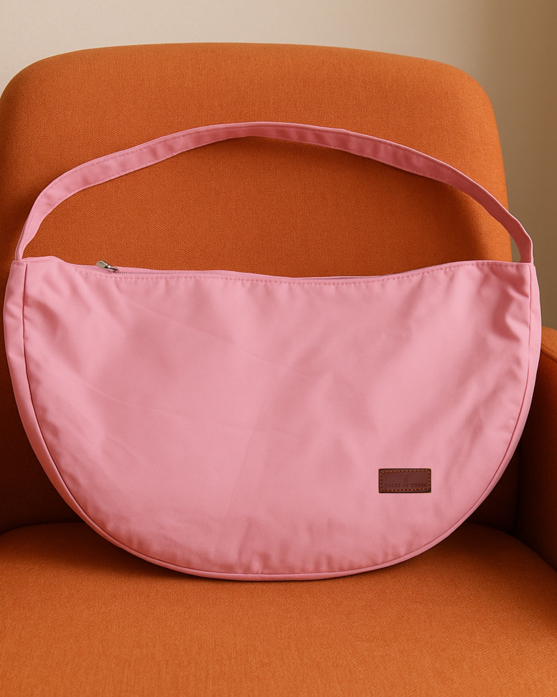 Half-moon shaped crossbody tote bag made from lightweight, water-resistant fabric – features a wide adjustable strap and secure top zipper closure. Minimalist design ideal for everyday carry, travel, or streetwear looks. A functional and fashion-forward piece from Tales of Totes, offering elevated casual utility for modern Indian shoppers."