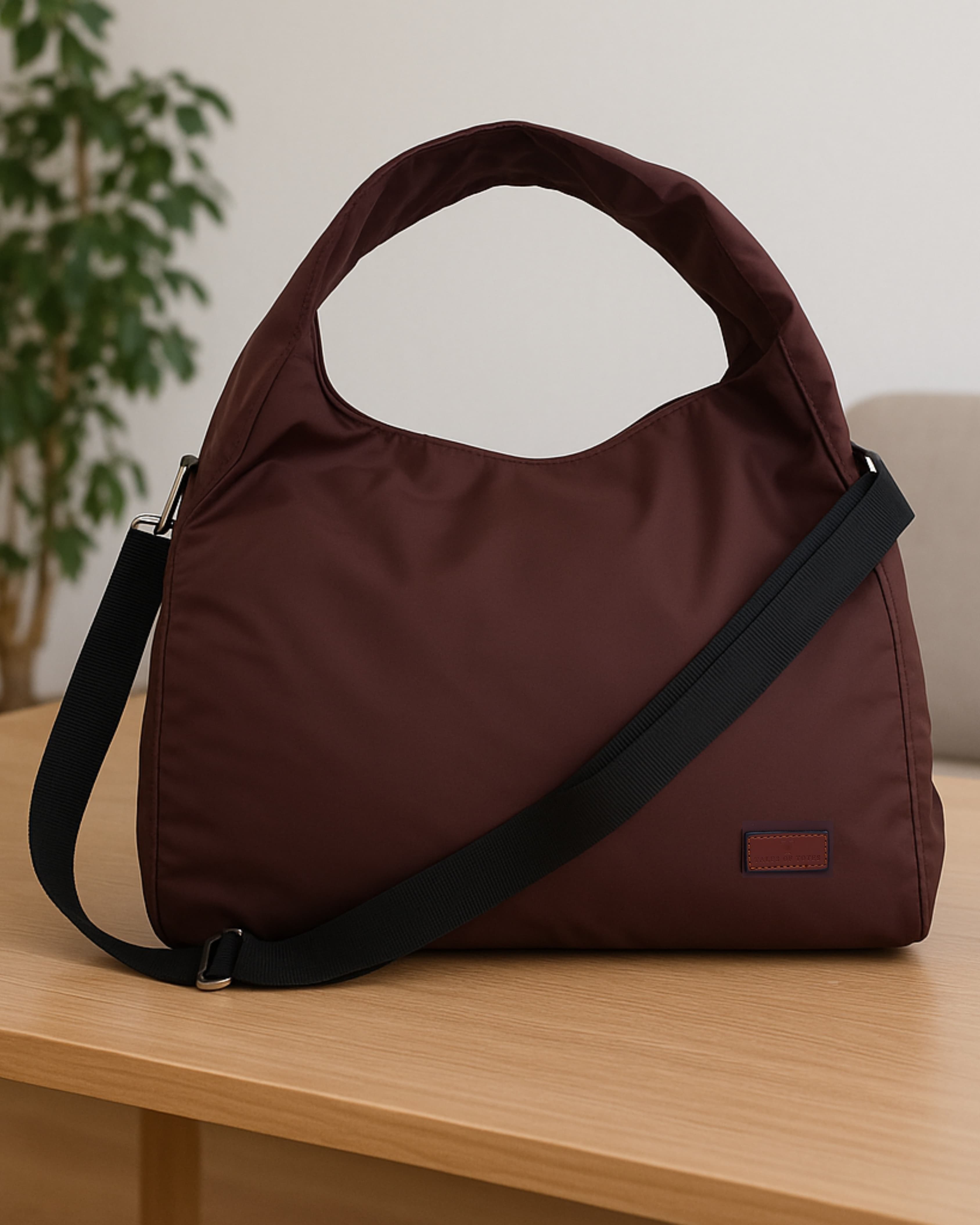 Minimalist black tote bag with a padded top handle, detachable crossbody strap, and front zipper pocket – made from water-resistant fabric for everyday functionality. Lightweight yet spacious, ideal for travel, office, gym, or casual use. A sleek and versatile design by Tales of Totes, offering modern utility and elevated style for Indian shoppers."