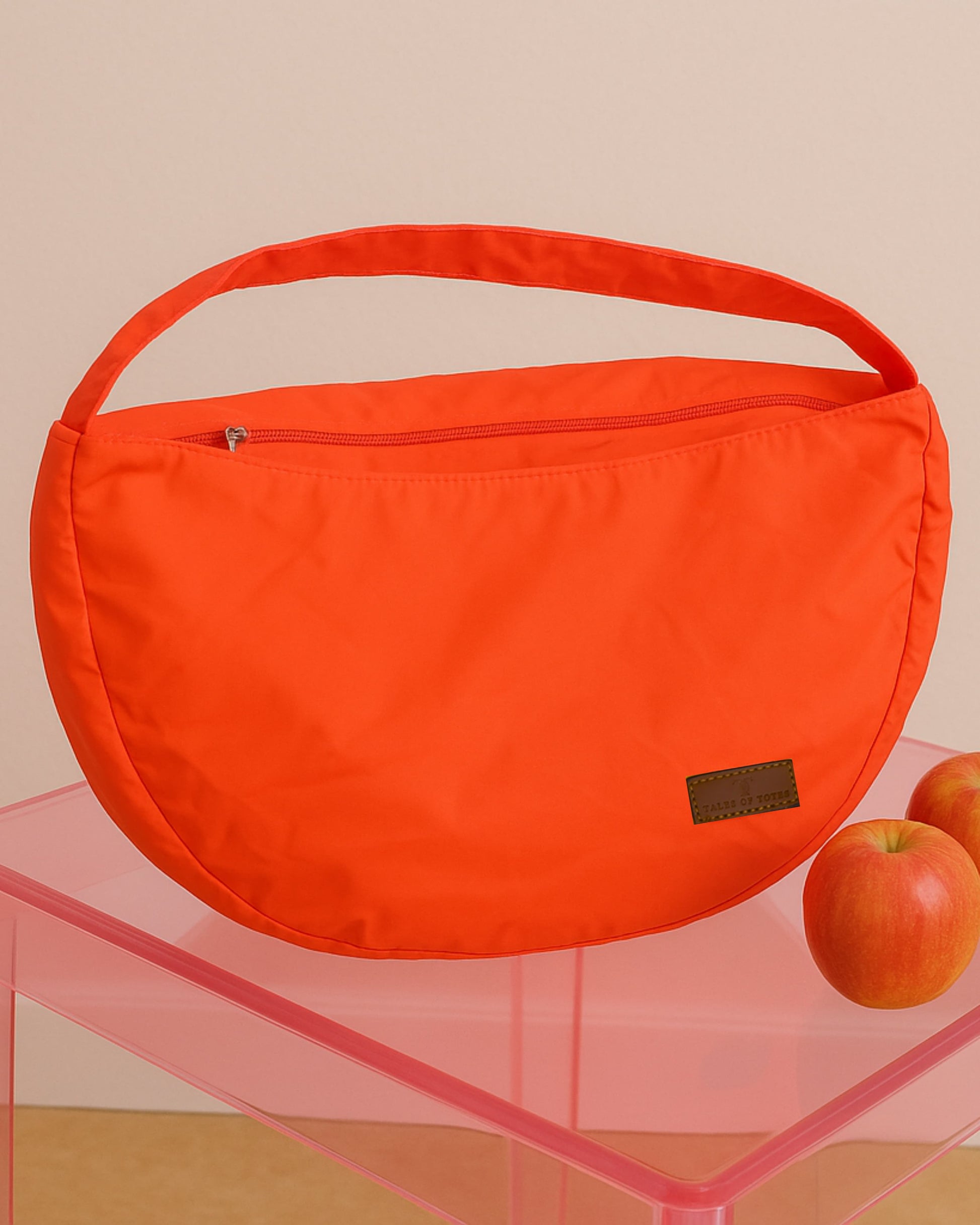 Half-moon shaped crossbody tote bag made from lightweight, water-resistant fabric – features a wide adjustable strap and secure top zipper closure. Minimalist design ideal for everyday carry, travel, or streetwear looks. A functional and fashion-forward piece from Tales of Totes, offering elevated casual utility for modern Indian shoppers."