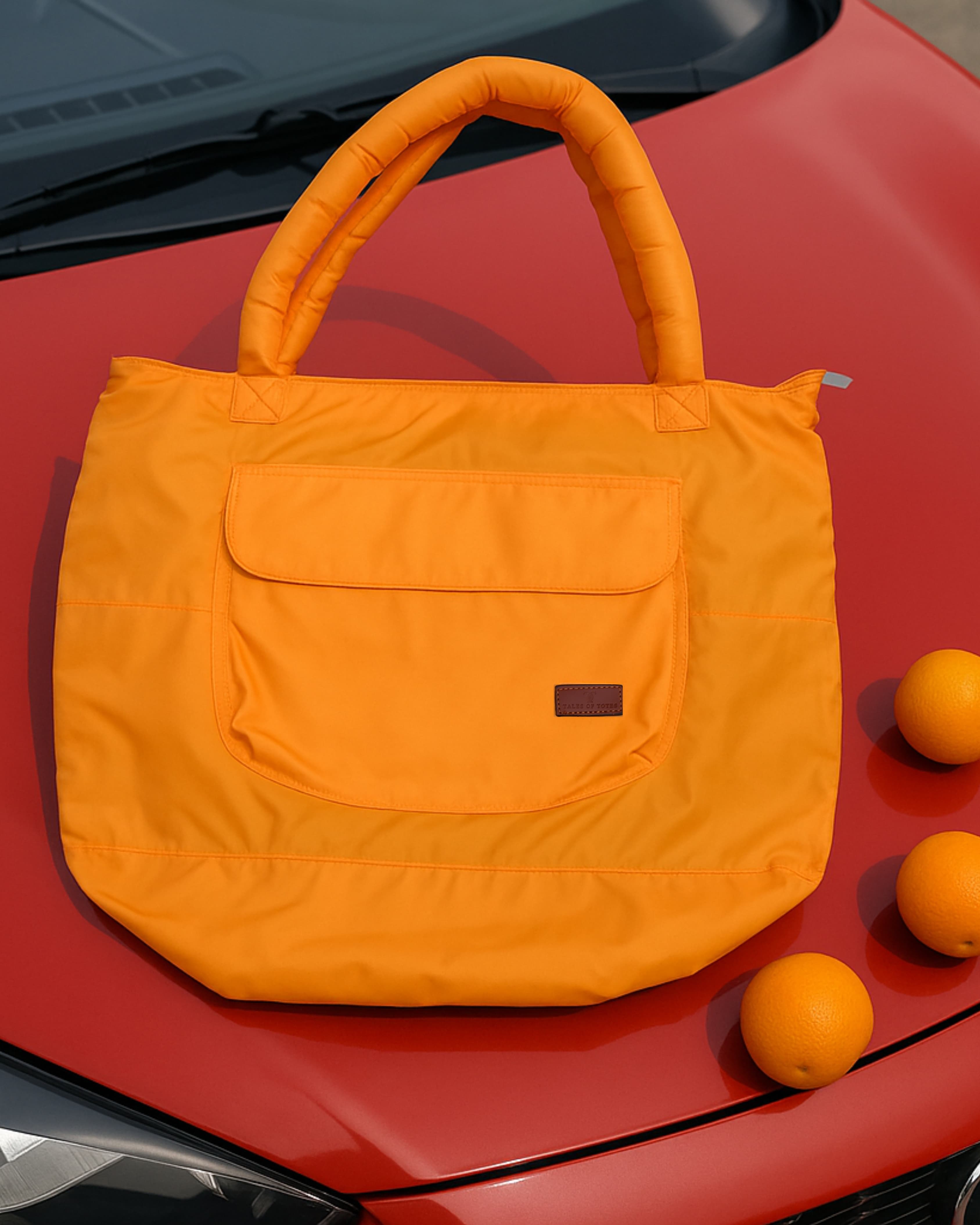 Lightweight nylon tote bag with a padded handle design and front flap pocket – perfect for everyday errands, gym, shopping, or casual travel. Spacious, foldable, and easy to carry with a functional structure that balances fashion and utility. A bold statement piece from Tales of Totes, designed for modern Indian lifestyles and a stylish alternative to basic canvas totes."

