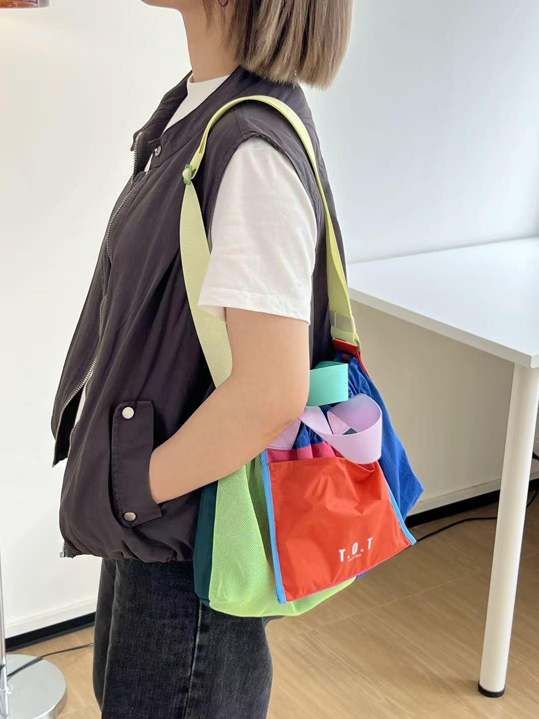 Trendy multi-color casual college tote bag with mesh detailing and adjustable straps.